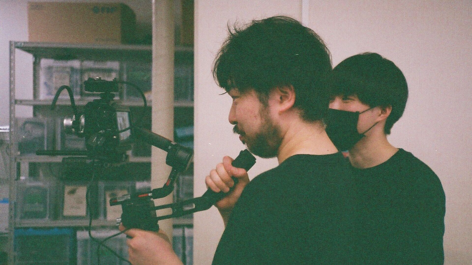 ジンバルにセットされたカメラを構える山本と鈴木の写真