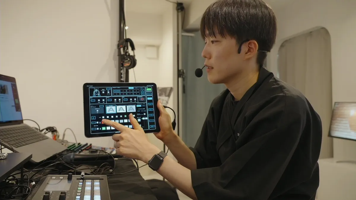 タブレットに表示されたRoland V-8HDのリモート操作画面を操作している様子。