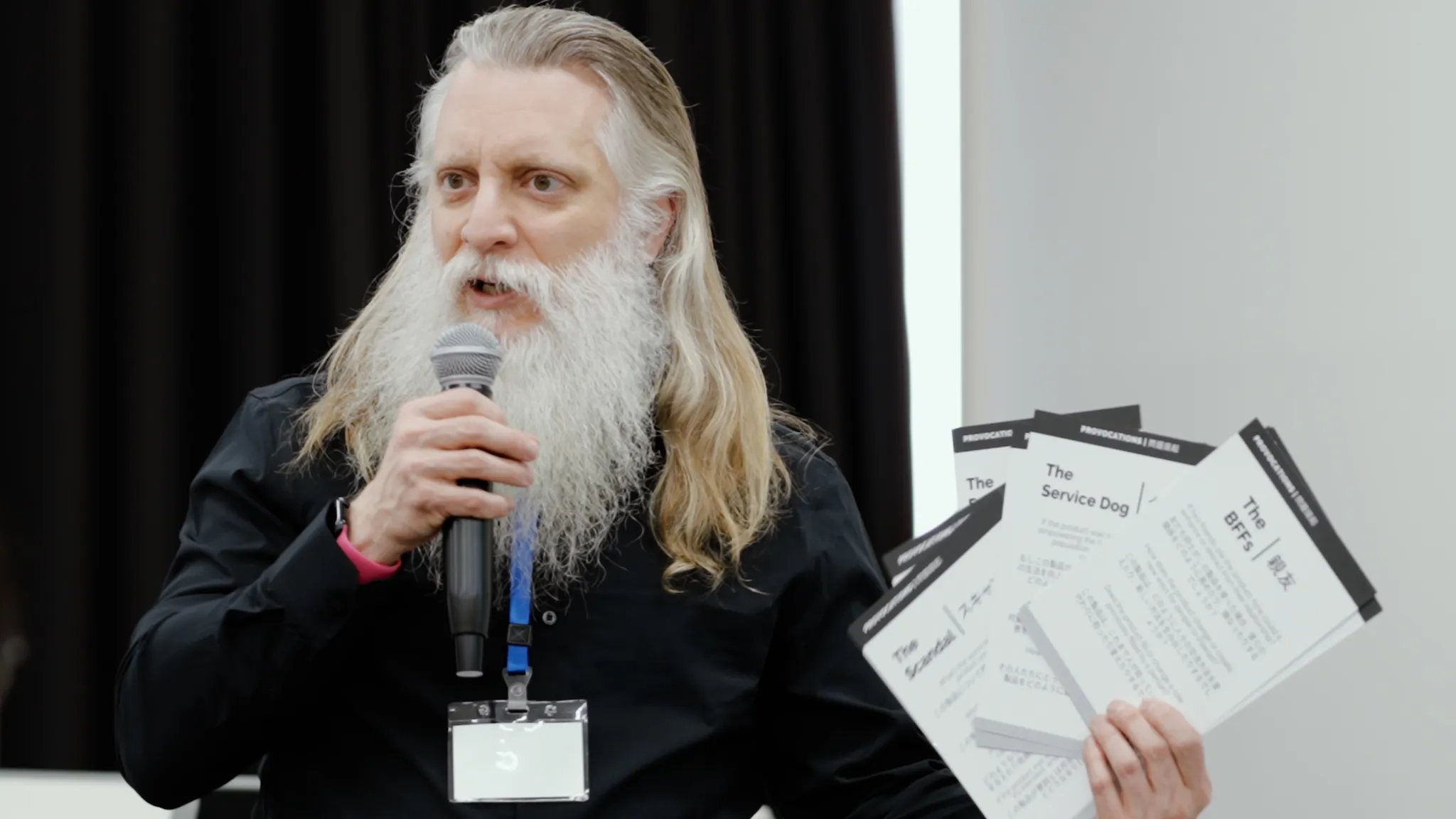 マイクを手に持ち、資料を見せながら話すDarrell Porcello 氏。
