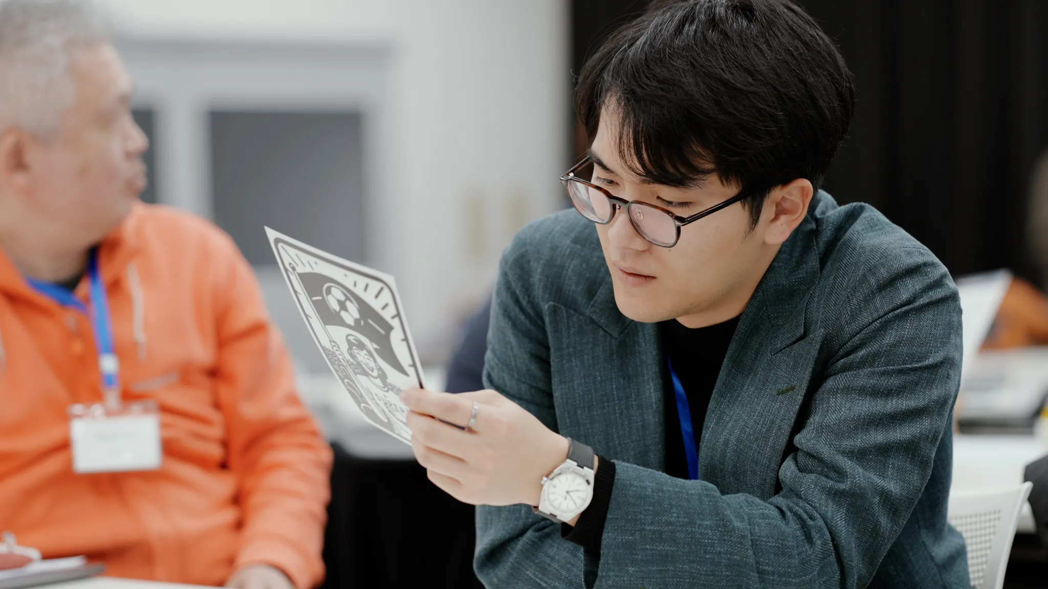 参加者が、手にしたカードを注意深く見ている。