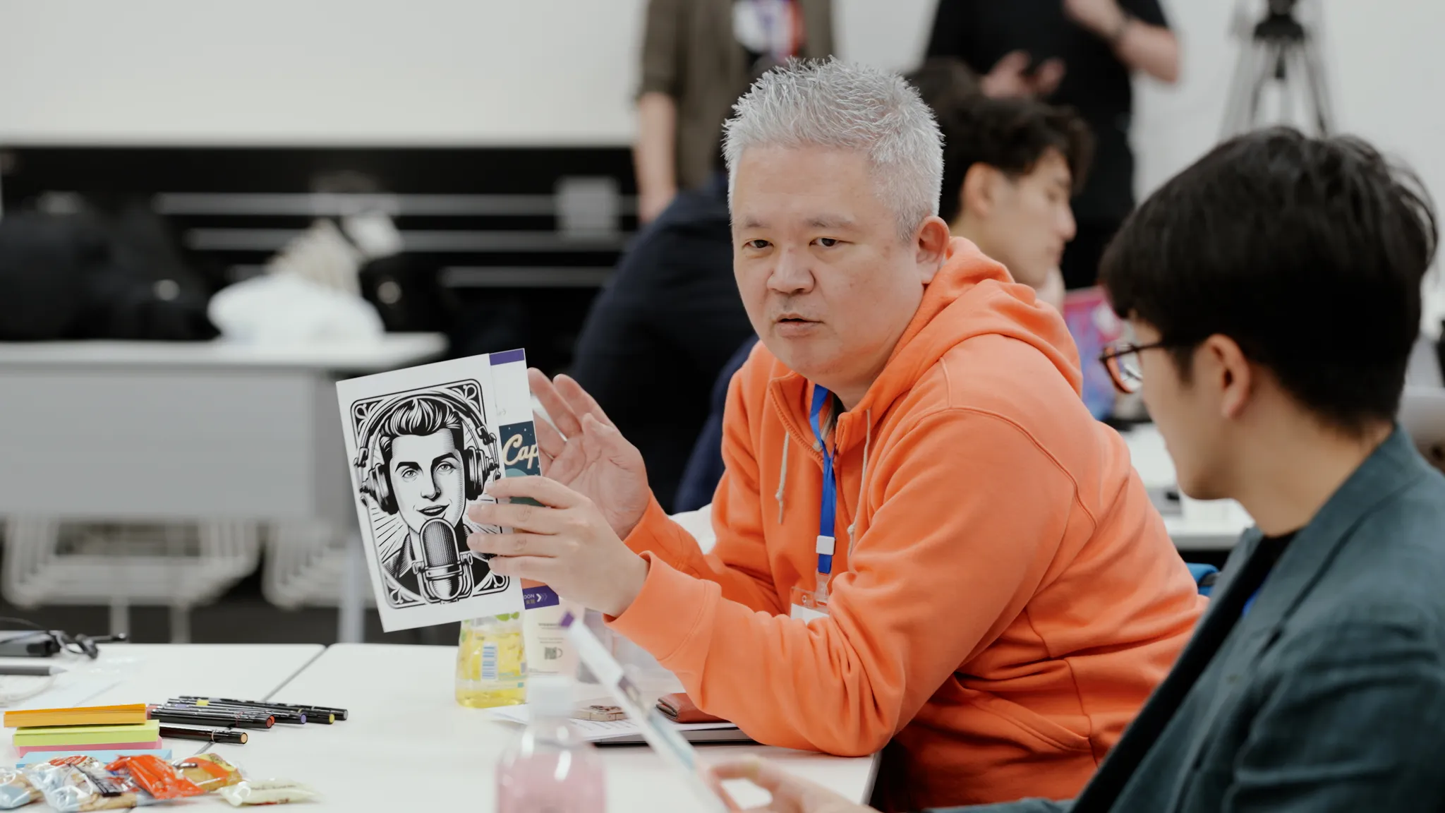ワークショップ中、イラストカードを手に持ち話している金井氏。