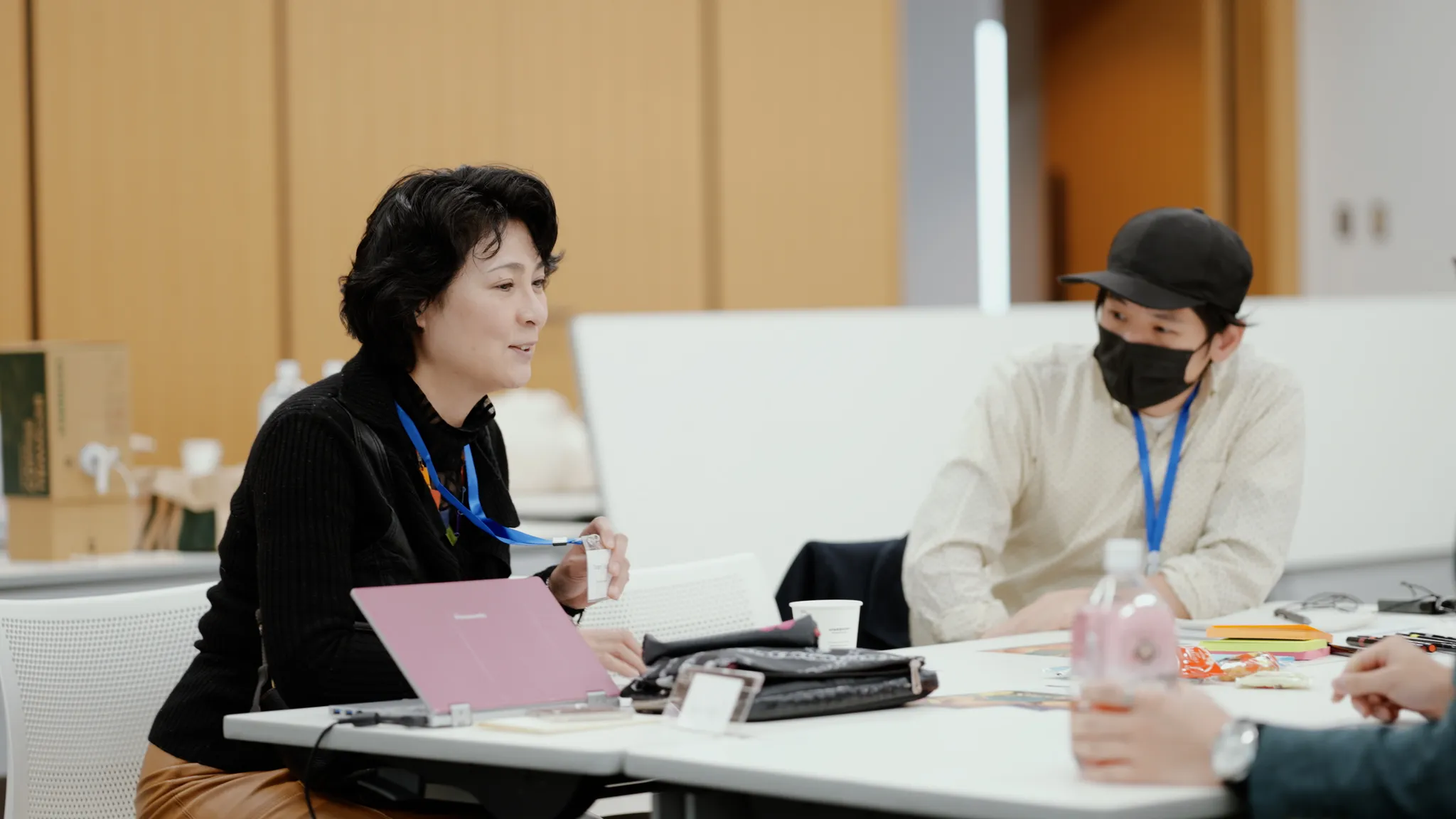 名札を見せながら自己紹介をする参加者と、それを見る別の参加者。