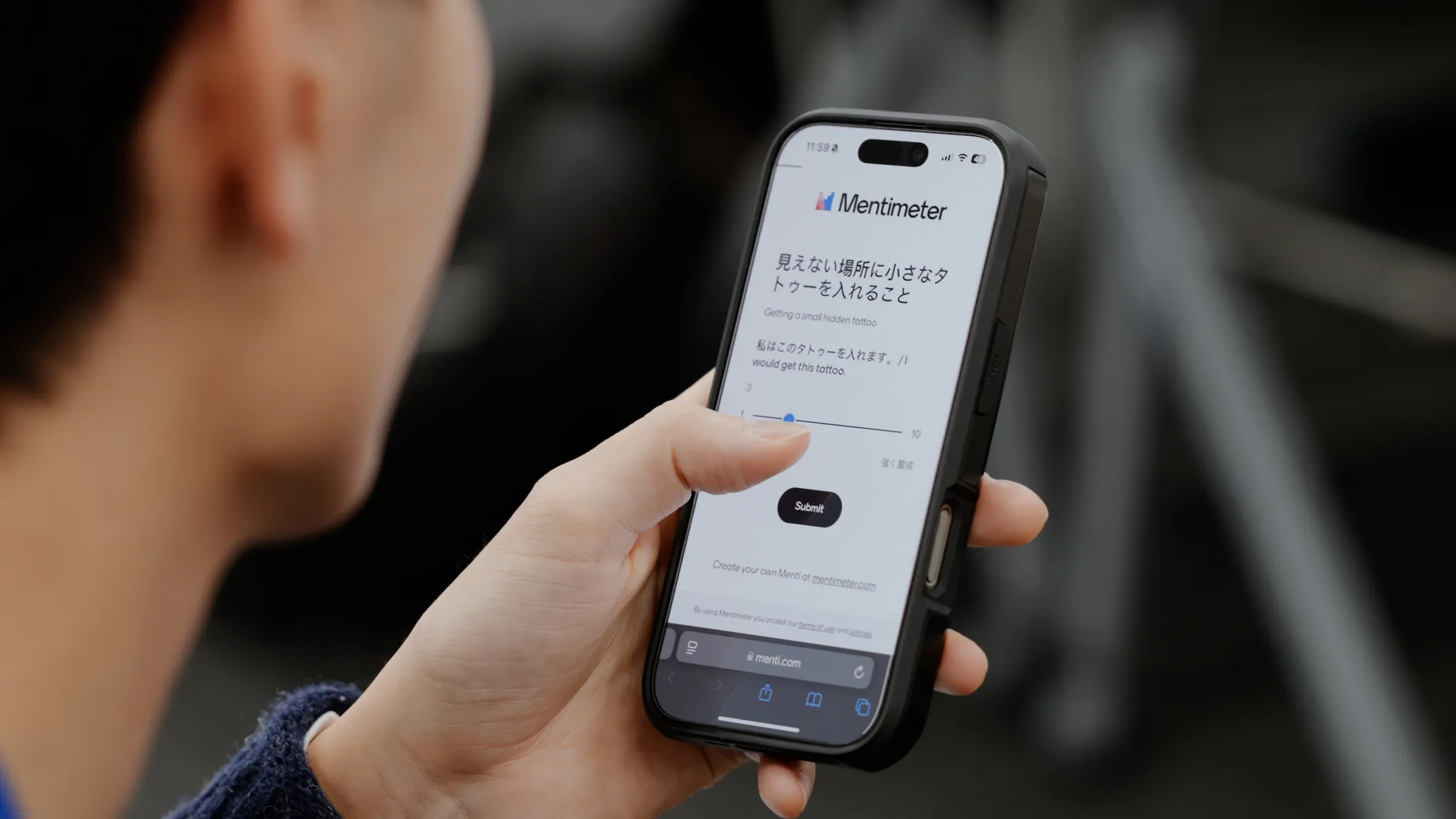スマートフォンで「Mentimeter」サイトを操作している手元。画面には質問「見えない場所に小さなタトゥーを入れること」「私はこのタトゥーを入れます」その下にスライドバーで1から10で賛成度合いを入力できる画面となっている。