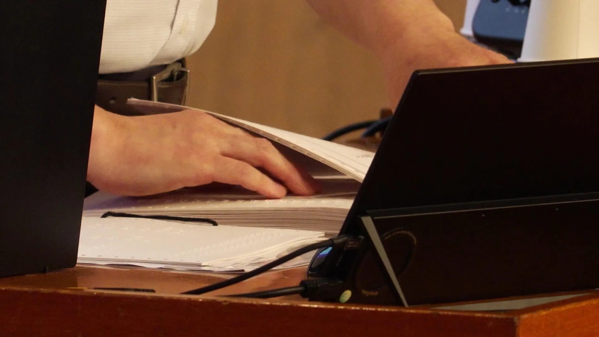 発表者の手元のクローズアップ。手が点字の文書のページをなぞっている様子。