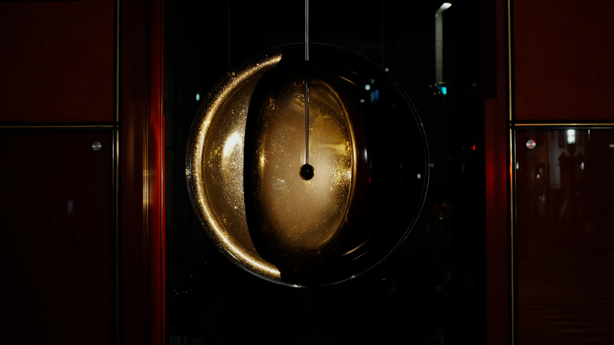 金色の大型のお椀のオブジェ、一埦中万物資生の全体を写した写真。お椀の蓋が回転しており、回転の中心にあるライトが蒔絵の金箔を照らしている。