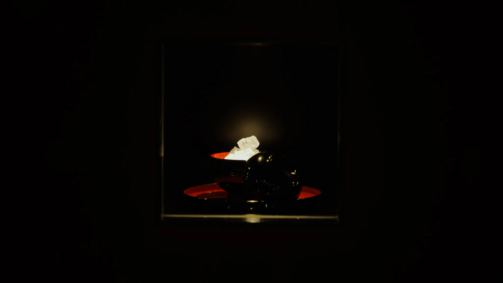 ショーケース内に展示された、黒いお椀に盛られた白い結晶。