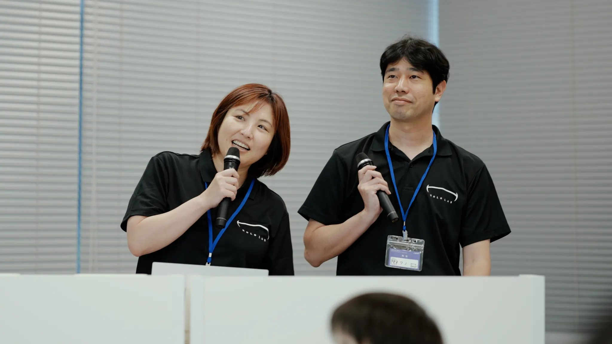 ホロラボの加茂氏と田野氏が演台の後ろに立ち、それぞれマイクを持って話している。