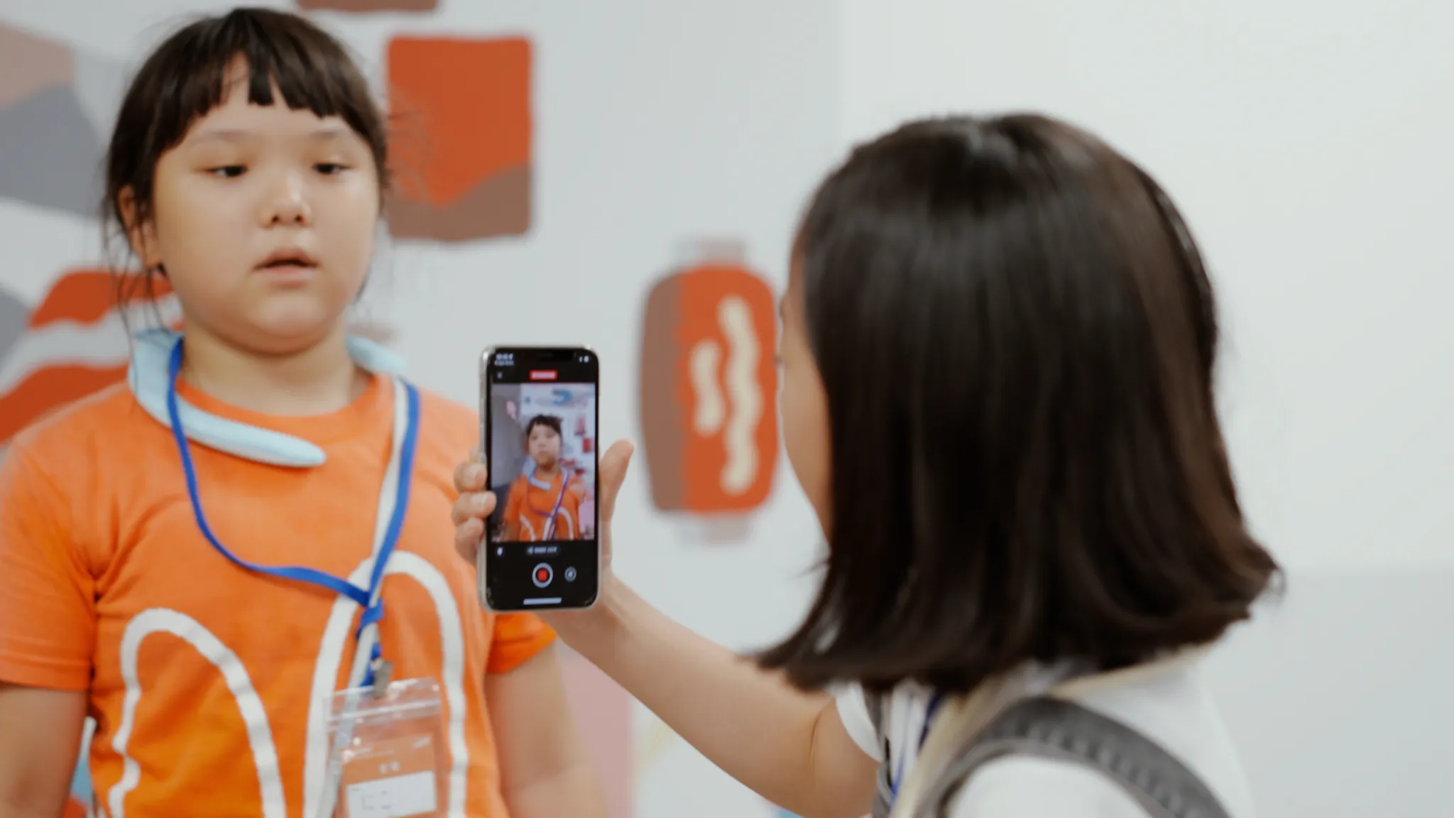 子どもが、別の子どもをスマートフォンでスキャンしている。