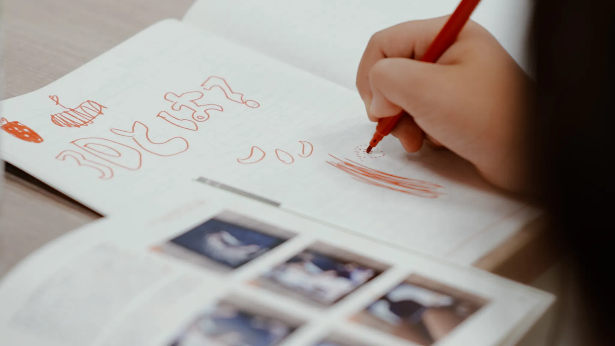 赤いペンでノートに「3Dとは?」と書いている手元。