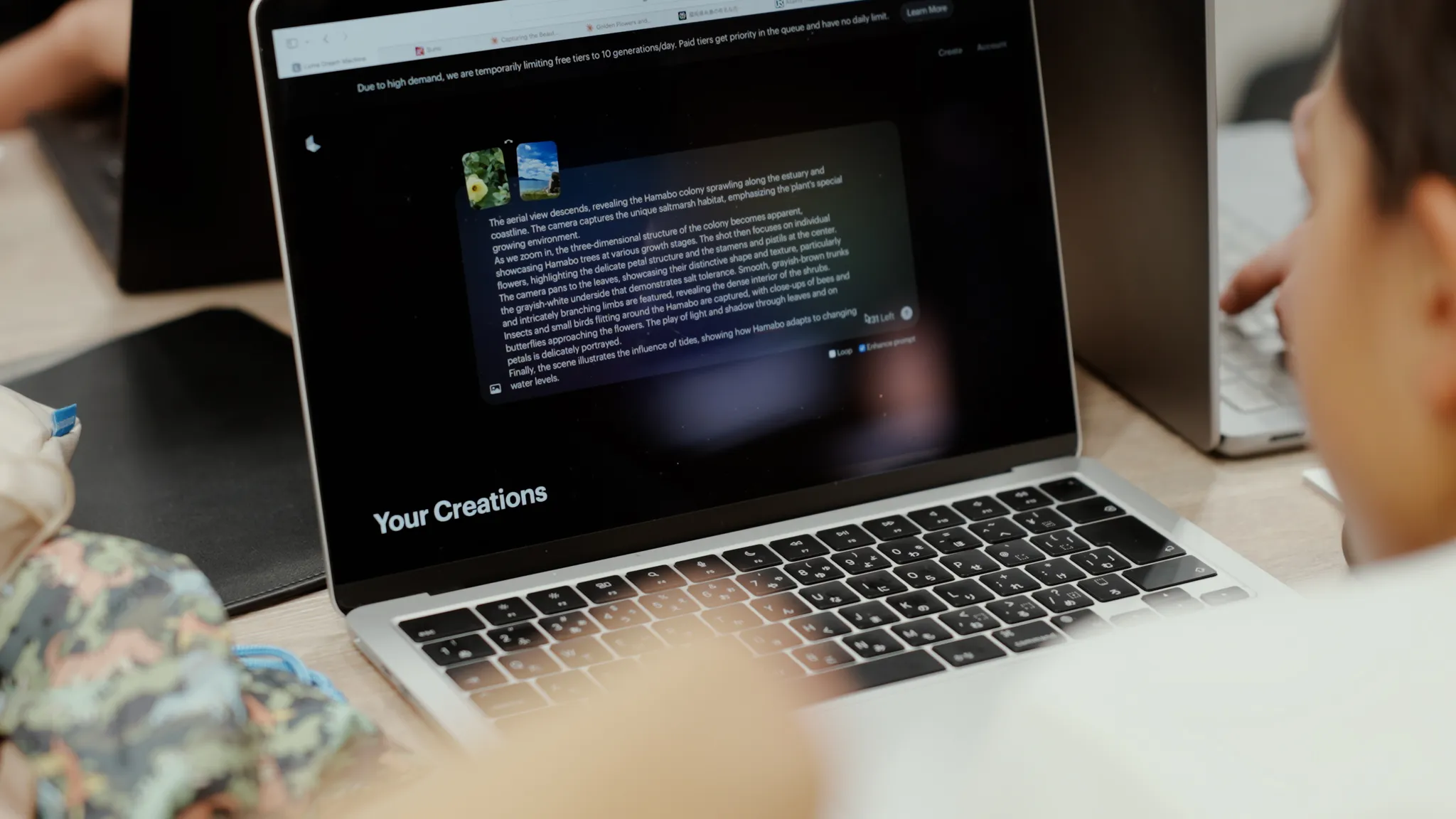 「Your Creations」と表示されたラップトップの画面。プロンプトとして英語の文章が書かれている。画像が添付されている。