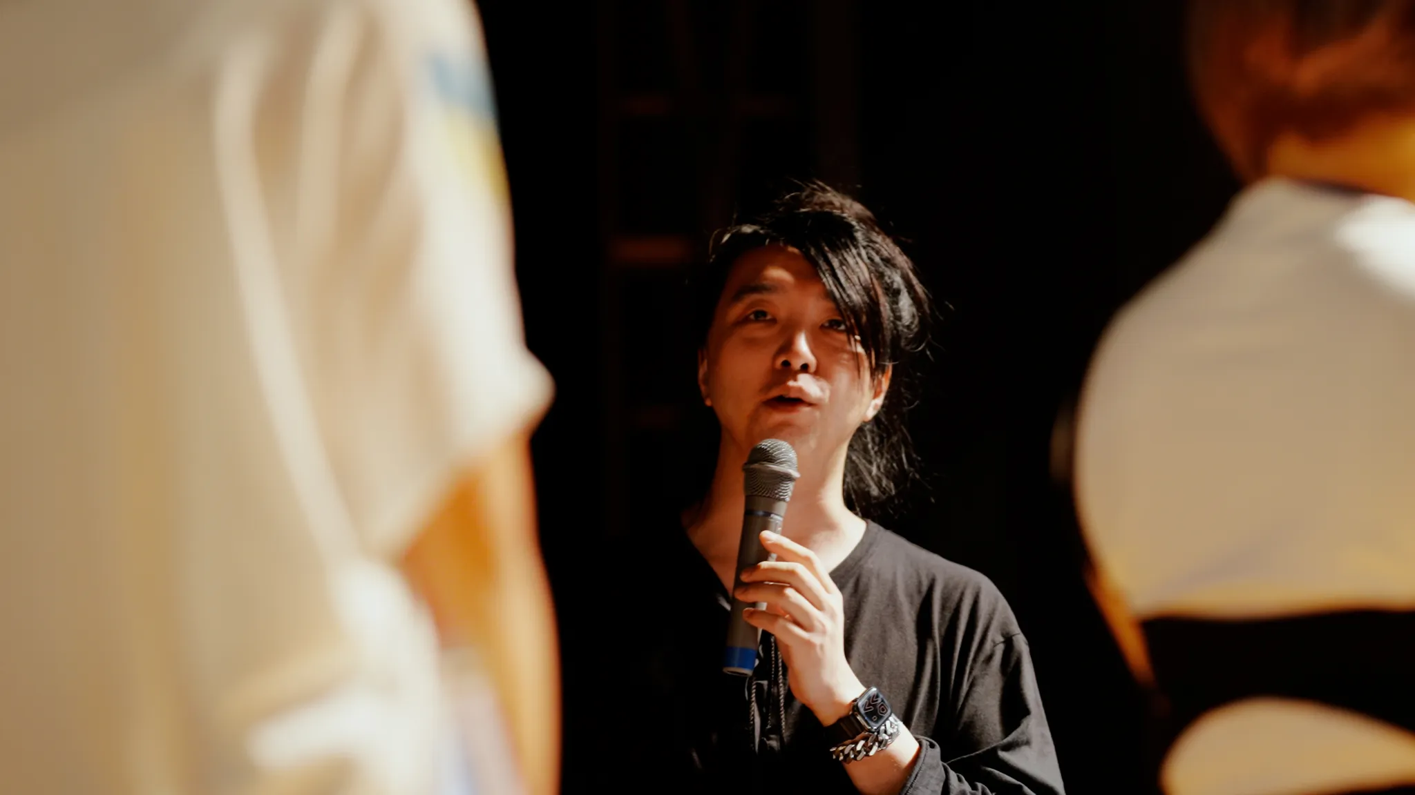 落合氏が子どもたちのほうを向き、マイクを持ち講評をしている。
