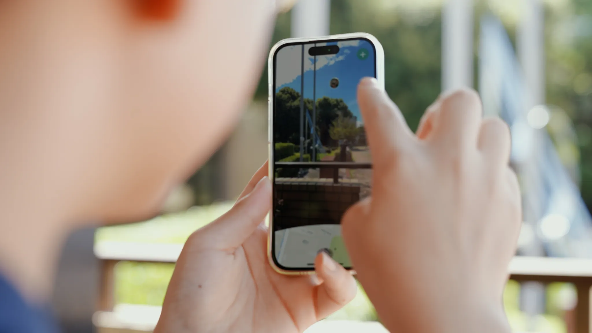 屋外でスマートフォンを操作する人物。画面にはARで3Dスキャンデータが重畳されている。