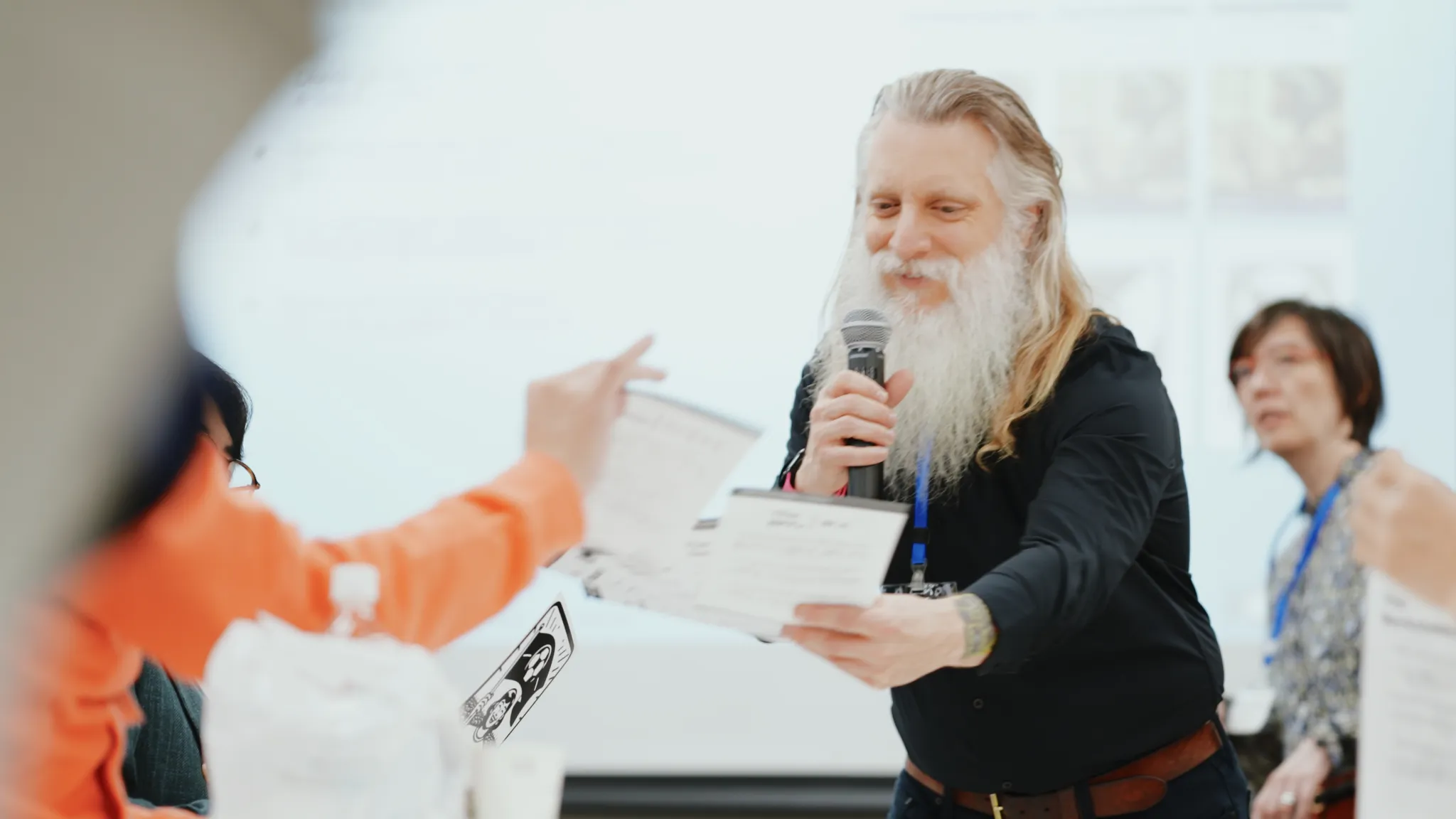 Darrell Porcello 氏がワークショップで使用するカードを参加者に手渡す様子。後ろに Karen Rommelfanger 氏。