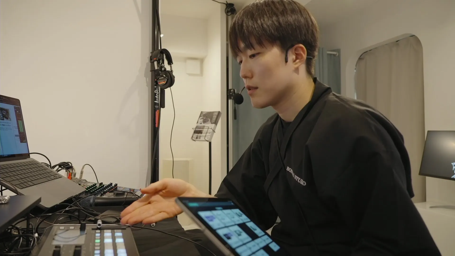 配信卓に設置されたRoland V-8HD映像スイッチャーを指しながら解説する様子。